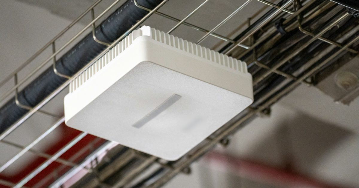 Ceiling-mounted Wi-Fi access point on a cable tray, part of a small business office network